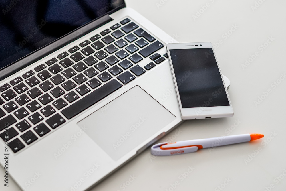 Laptop, telephone, pen on the gray table. Office work. High quality photo Laptop, telephone, pen on the gray table. Office work. High quality photo