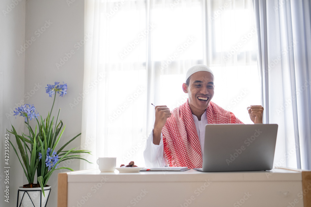 excited success businessman raise his arm while using laptop excited success businessman raise his arm while using laptop