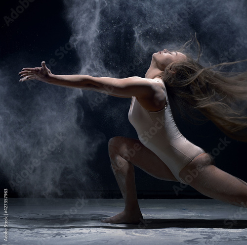 Contemporary dancer performing in cloud of powder