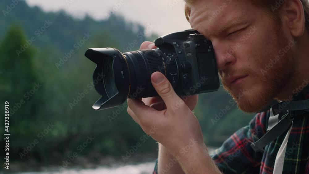 Man taking photos on photo camera. Male tourist adjusting zoom on camera lens