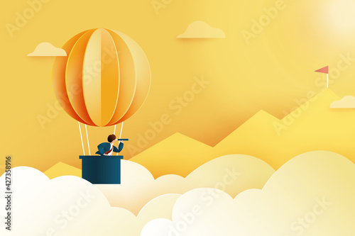 Businessman with telescope in hot air balloon searching for red flag on the peak of mountain.Successful and business concept.