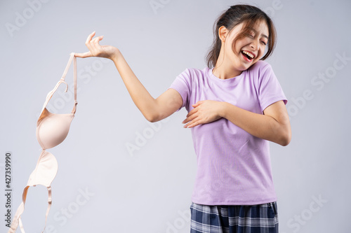 Принти на полотні The young Asian girl took off her bra with a happy face