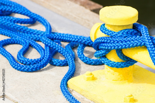 Blue rope and mooring bollard, detail of seaport, yachting concept