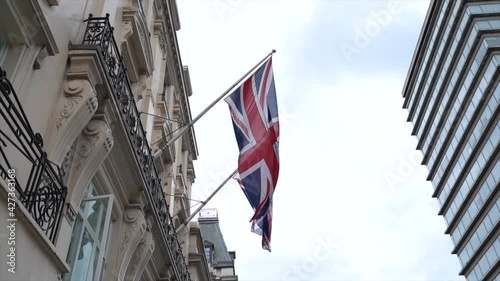 A low angle shot of UK flag waving embassy in London, England in 4K photo