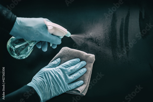 Cleaning surfaces as coronavirus infection spreading prevention. Clean surface hygiene in public spaces, offices, hospital for healthcare workers disinfecting home with medical PPE blue gloves.