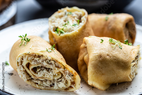 Delicious crepes rolls with chicken meat and cheese. Traditional Russian Shrovetide Maslenitsa festival meal. Food recipe background. Close up