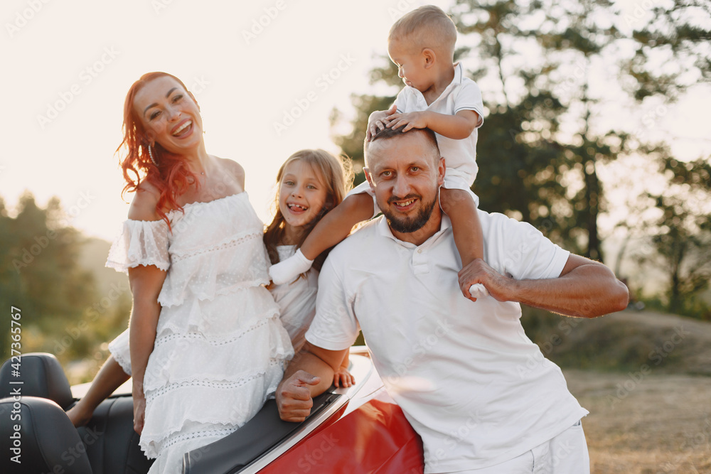 Family in a cabriolet convertible car at the sunset Family in a cabriolet convertible car at the sunset