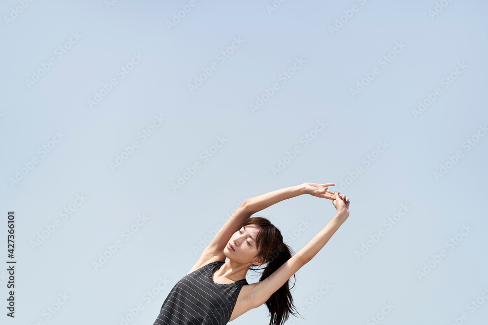 young asian woman stretching arms outdoors young asian woman stretching arms outdoors