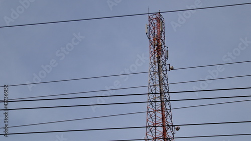 Mobile phone Telecommunication Radio antenna Tower. Cell phone tower with blue sky background, obstructed the power cord in front
