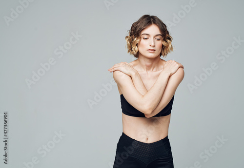 Woman doing exercises gesturing with hands on gray background Copy Space