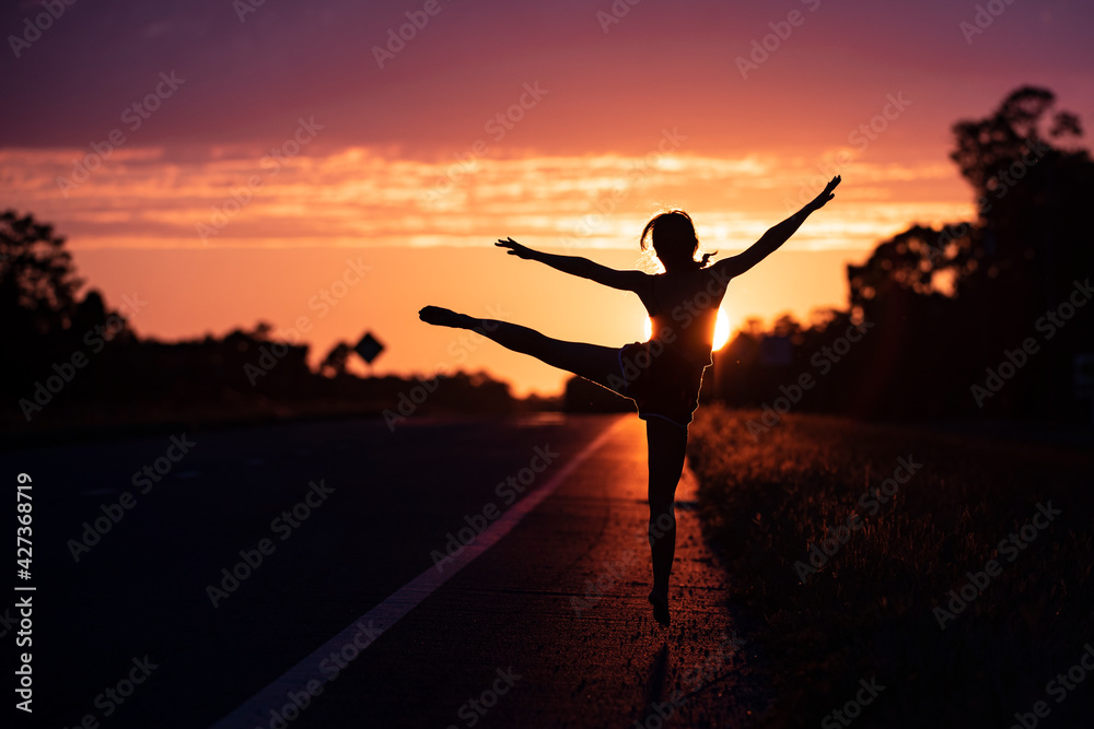 Young woman dancing in summer sunset sky outdoor. People freedom.