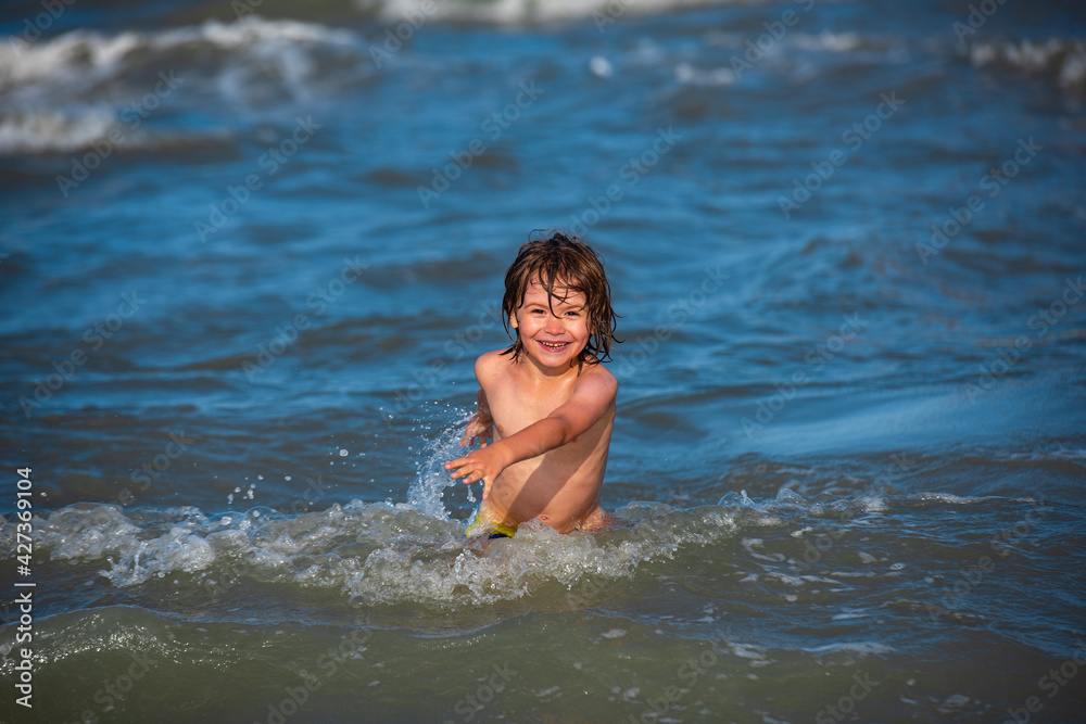 Happy kids have fun in sea on beach. Happy child playing in the sea. Kids jumping near the waves.
