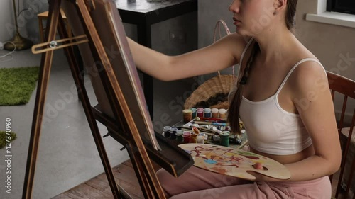 Calm woman painting in light home studio