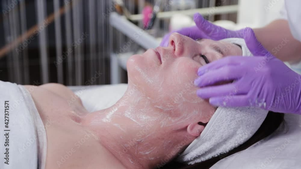Woman beautician doing facial massage to young woman.