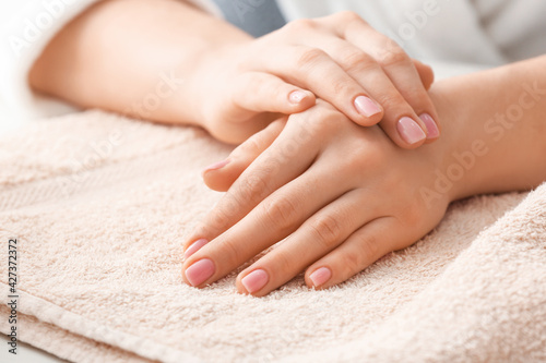 Beautiful female hands and towel on light background