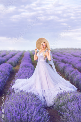 beautiful woman in a long purple dress on a background of lavender . A girl in the form of a fairy and a nymph of flowers