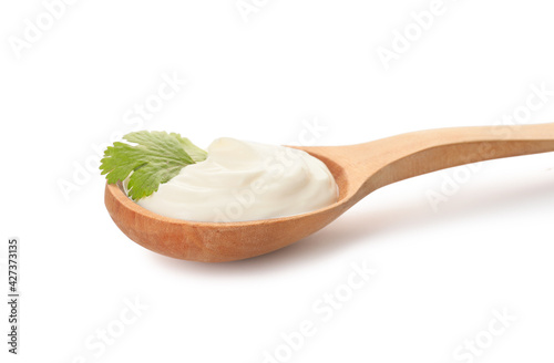 Spoon with tasty sour cream on white background