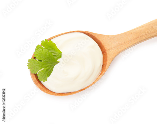 Spoon with tasty sour cream on white background