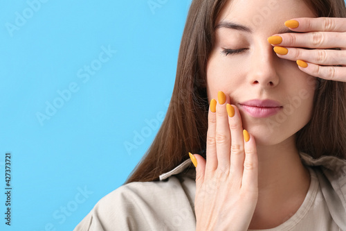 Young woman with beautiful manicure on color background