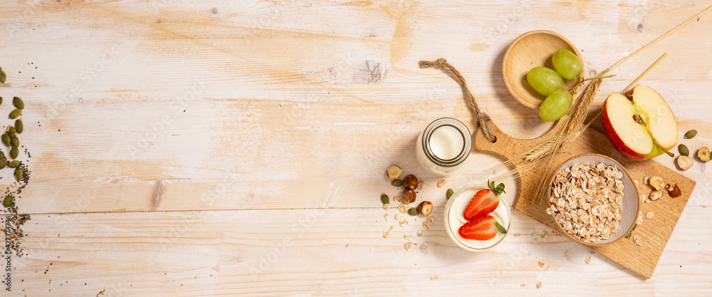 Healthy breakfast with strawberry, apple, oats nuts and seeds on wooden background with copy space Healthy breakfast with strawberry, apple, oats nuts and seeds on wooden background with copy space