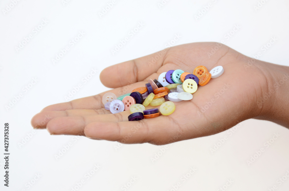 the colorful button holding hand isolated on white background. the colorful button holding hand isolated on white background.