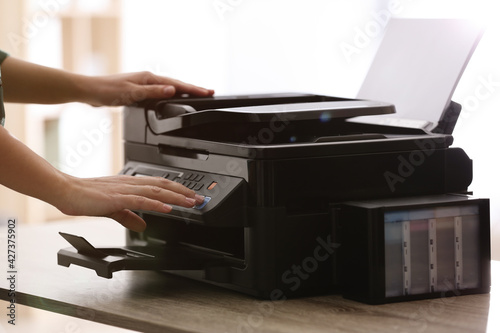 Employee using modern printer in office, closeup