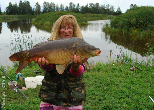 happy woman with big carp, carp fishing, spending free time fishing