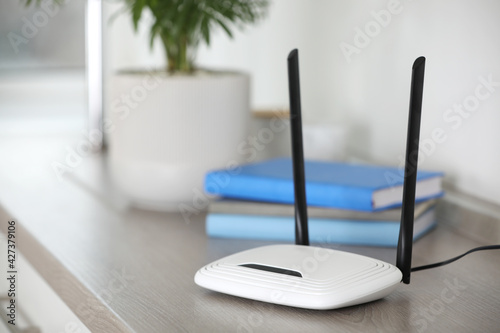 Modern Wi-Fi router indoors. Space for text photo