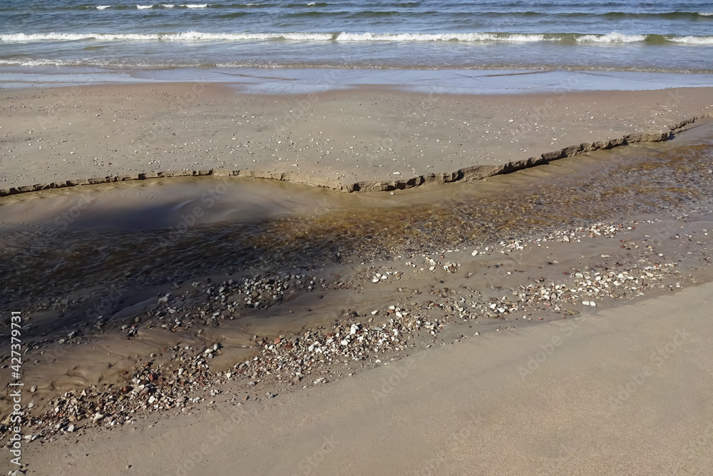 The river floating to the sea, sand, pebble, sunny day, wave coming The river floating to the sea, sand, pebble, sunny day, wave coming