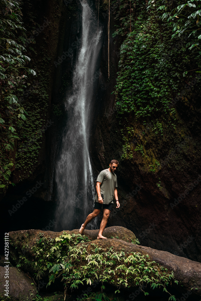 A man at the waterfall. A person travels around the world. The man at the waterfall. Travel to Bali, Indonesia. A person travels through picturesque places. A lone traveler. Copy space A man at the waterfall. A person travels around the world. The man at the waterfall. Travel to Bali, Indonesia. A person travels through picturesque places. A lone traveler. Copy space