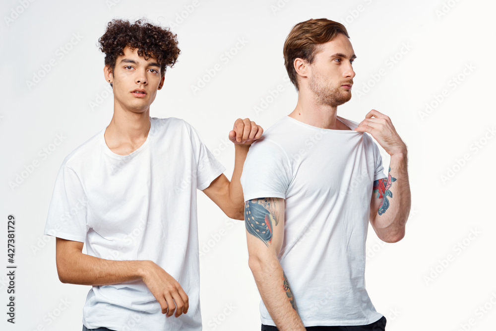 two men in white t-shirts stand side by side cropped view studio two men in white t-shirts stand side by side cropped view studio