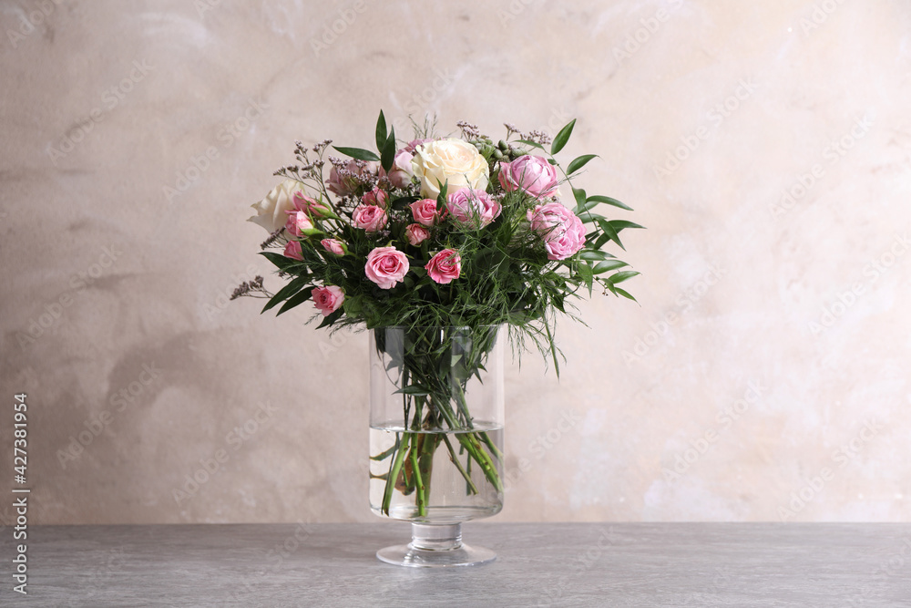 Beautiful bouquet with roses on table against grey background - obrazy, fototapety, plakaty 