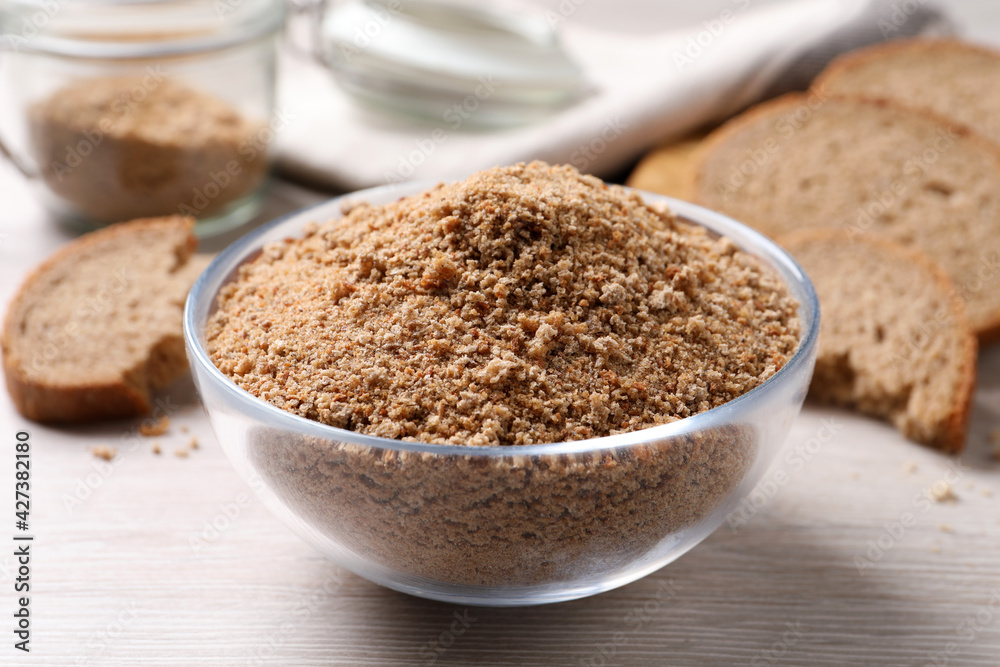 Fresh breadcrumbs in bowl on white wooden table Fresh breadcrumbs in bowl on white wooden table