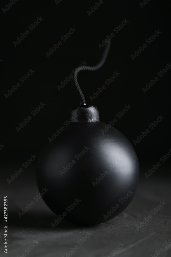 Sphere shaped bomb with burning fuse on black background