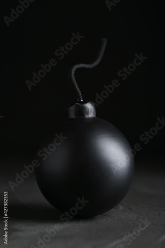 Sphere shaped bomb with burning fuse on black background