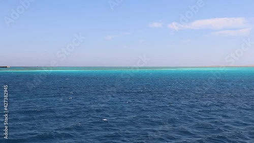 Wallpaper Mural Seascape in motion, panoramic view of the azure waters of the Red Sea, turquoise coral reefs in the distance, white desert sand on the horizon, red lighthouse in the sea Torontodigital.ca