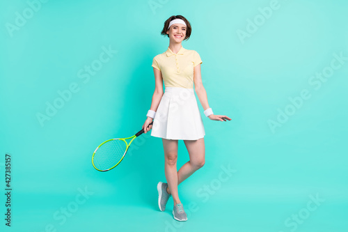 Full length body size view of nice experienced sportive cheerful girl playing tennis posing isolated over bright teal turquoise color background © deagreez