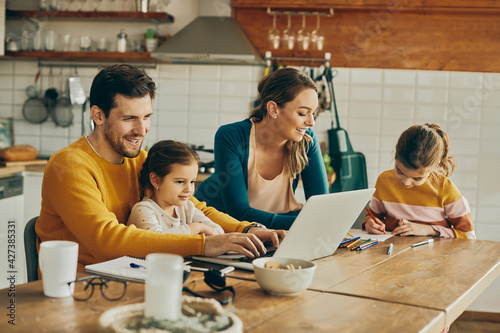 Happy dedicated parents enjoying the time they are spending with their daughters at home. photo