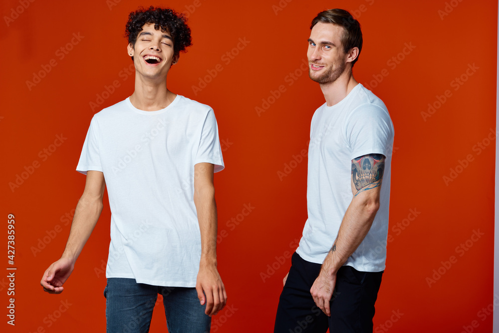 Two cheerful men on t-shirts communication friendship red background Two cheerful men on t-shirts communication friendship red background