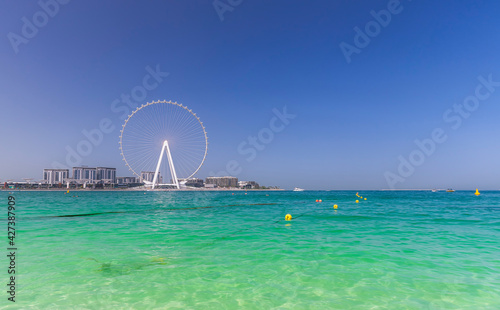 Dubai, UAE - March 04, 2021: Ferris wheel on Dubai Marina beach photo