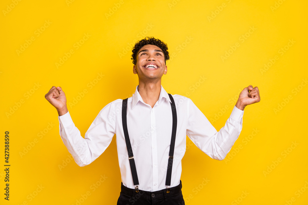 Fototapeta premium Photo portrait of african american man praying looking up celebrating isolated on vivid yellow colored background