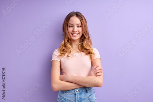 Teenager caucasian girl isolated on purple background keeping arms crossed in frontal position