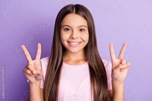 Photo of young cheerful girl happy positive smile show peace cool v-sign isolated over violet color background