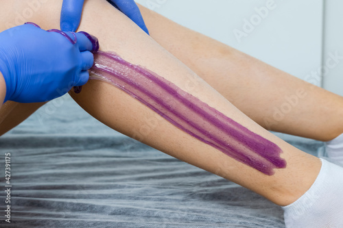 Closeup of Beautician Hands Accomplishing Woman Legs Depilation By Using Sugaring Technique on Female Legs