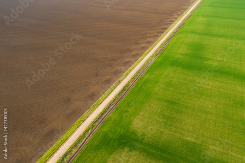 aerial view of an old country road between agricultural fields in spring