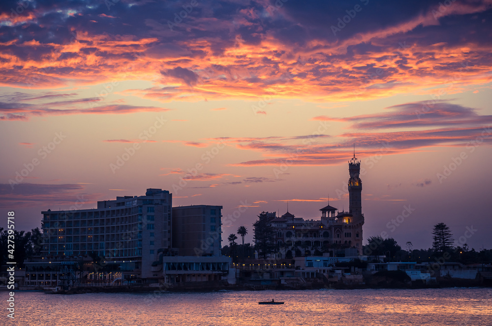 Sunset over Alexandria city with silhouettes of Royal Palace and Montazah Park, Egypt.