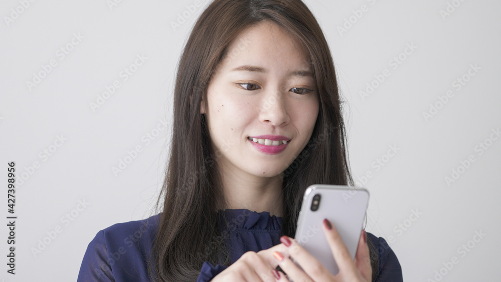 家でスマホを操作する若い女性 家でスマホを操作する若い女性