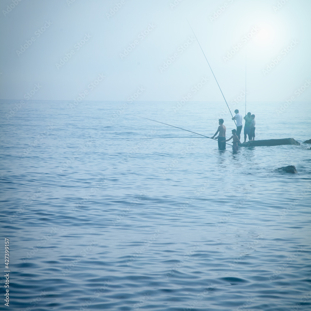 Silhouette of fishermen fishing at sea. Summer leisure, sport, holiday concept.