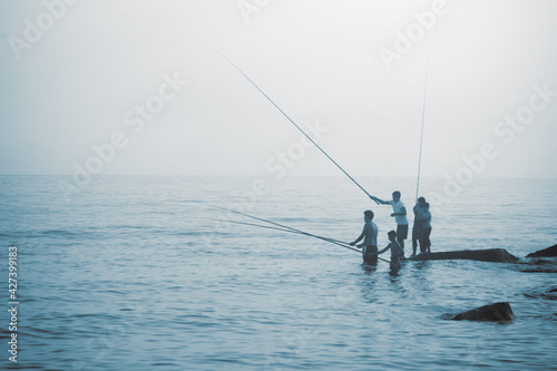Silhouette of fishermen fishing at sea outdoors. Summer leisure, sport, holiday concept.