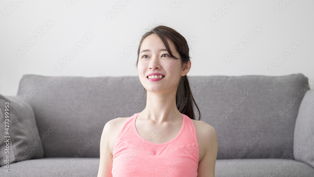 家でストレッチする若い女性 家でストレッチする若い女性